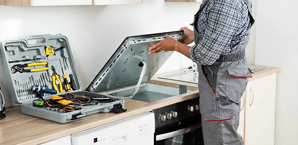 Handyman repairing a cooktop and checking wiring connections in Columbus, GA